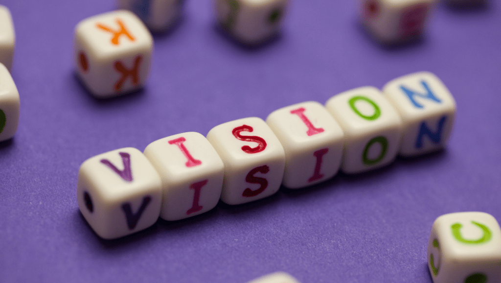 The word "vision" spelled out in colorful alphabet dice